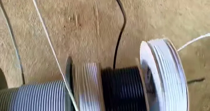 Three drums of cable on the floor of a new build, grey, black and white, ready to be run